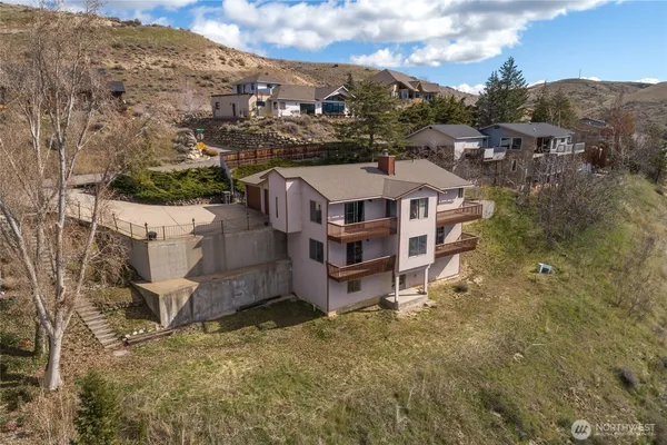 an aerial view of a house with a yard and mountain view in back
