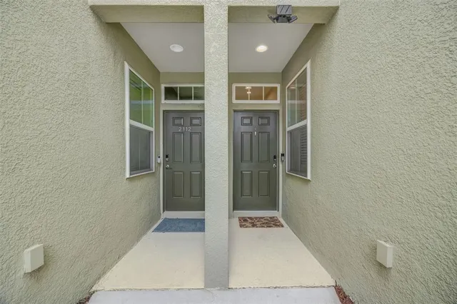 a view of a hallway with wooden floor and a bathroom