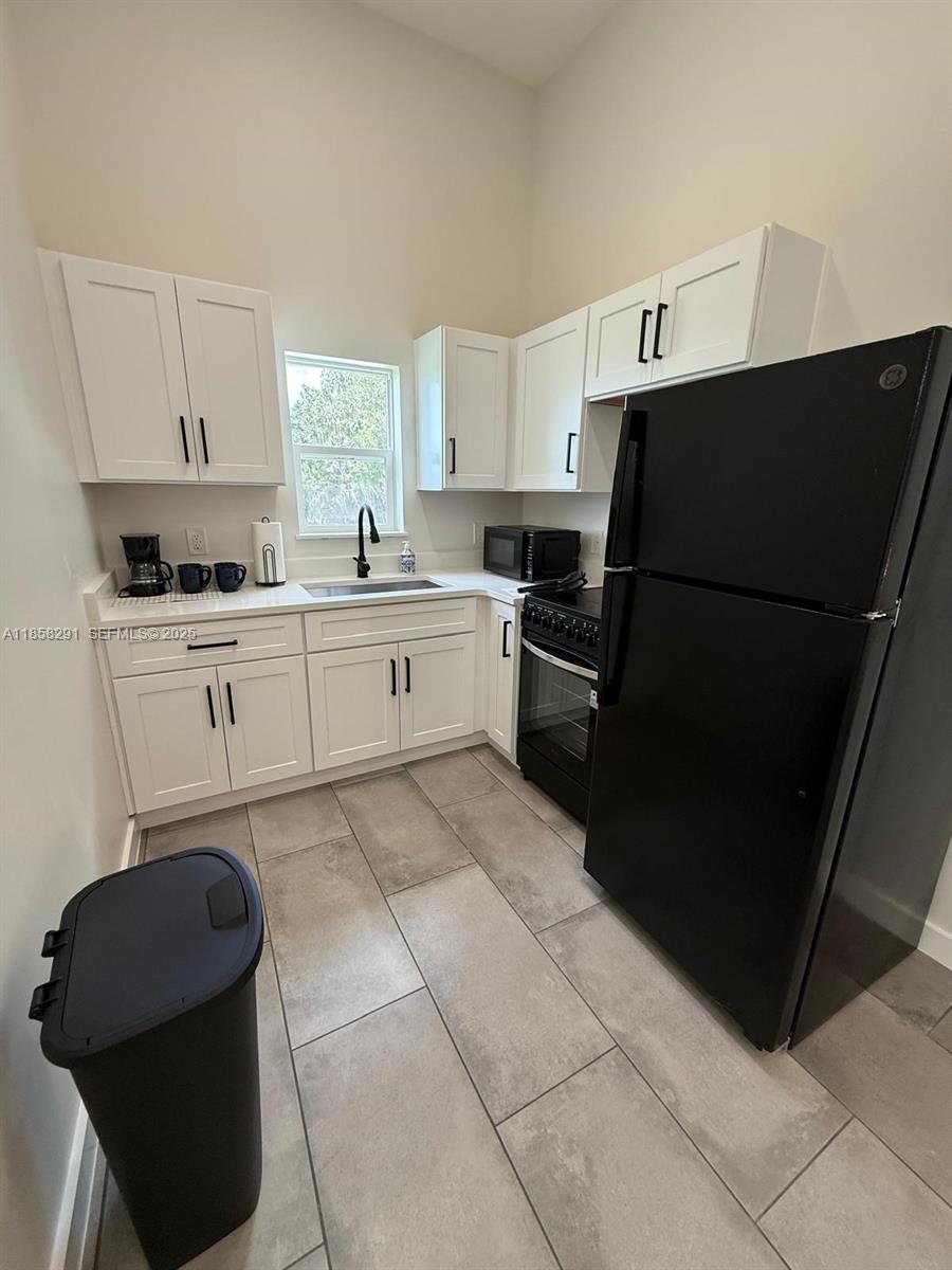 20925 Northwest 100th Avenue Road Micanopy, FL 32667 - Photo 11 of 19 a kitchen with a refrigerator and a stove top open