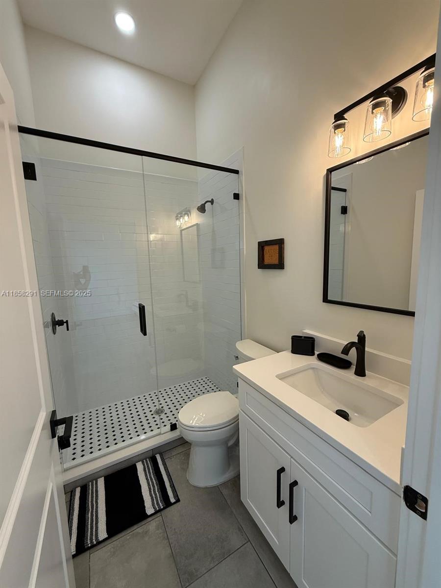20925 Northwest 100th Avenue Road Micanopy, FL 32667 - Photo 12 of 19 a bathroom with a sink a toilet a mirror and shower
