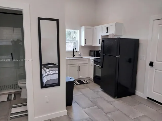 a kitchen with a refrigerator and a stove top open