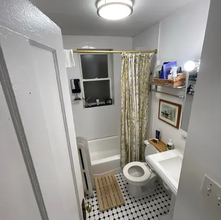a bathroom with a toilet a sink and mirror