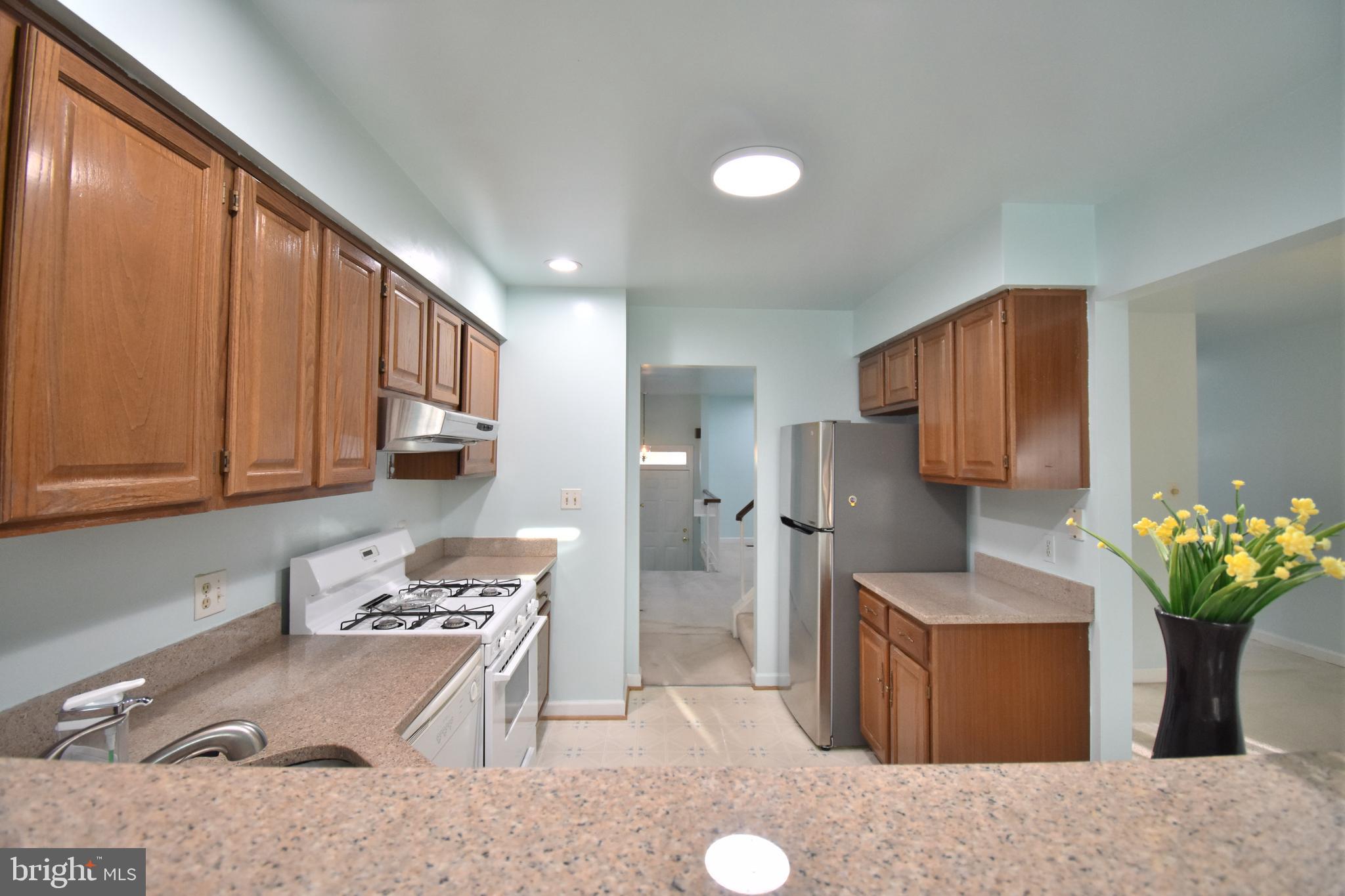 13233 Copeland Court Silver Spring, MD 20904 - Photo 7 of 20 a kitchen with stainless steel appliances granite countertop a sink a stove a refrigerator cabinets and living room view