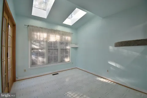 a view of an empty room with a fireplace and a window