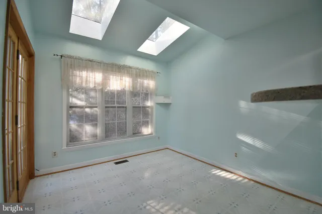 a view of an empty room with a fireplace and a window