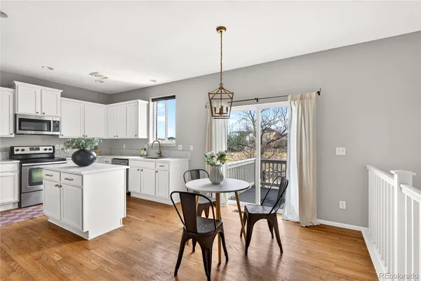 a kitchen with white cabinets and wooden floor