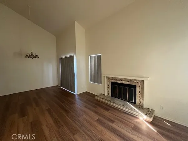 a view of empty room with wooden floor and fireplace