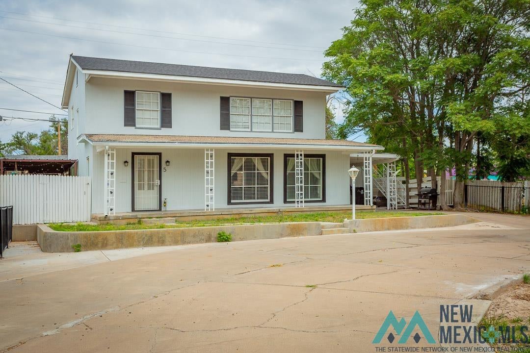 5 Riverside Drive Roswell, NM 88201 - Photo 1 of 1 View of front of house with covered porch, stucco siding, a shingled roof, and concrete driveway
