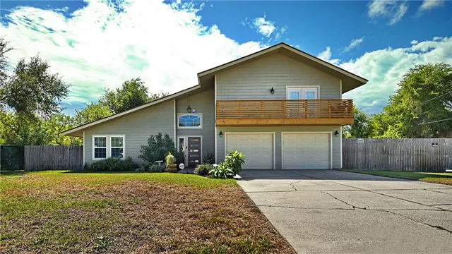 a front view of house with yard and trees around