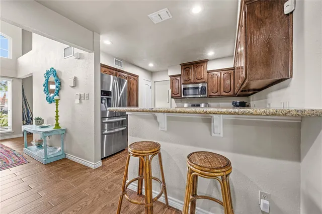 a kitchen with stainless steel appliances granite countertop a refrigerator and a stove top oven