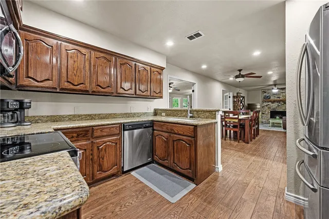 a kitchen with stainless steel appliances granite countertop a stove a sink and a microwave