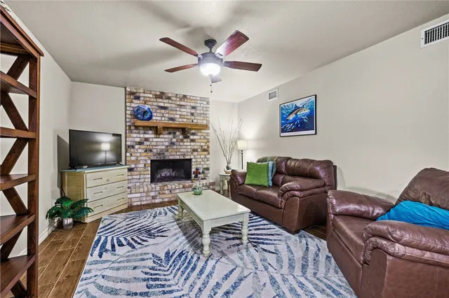 a living room with furniture a flat screen tv and a fireplace