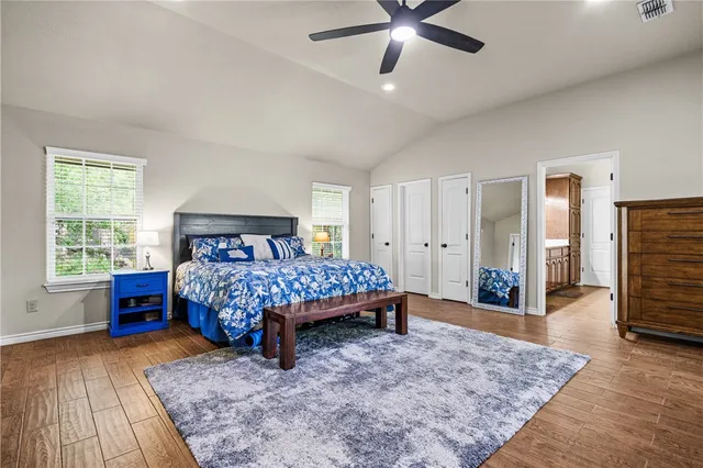 a bed sitting in a spacious bedroom next to a window