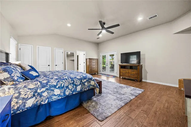 a spacious bedroom with a bed and a flat screen television