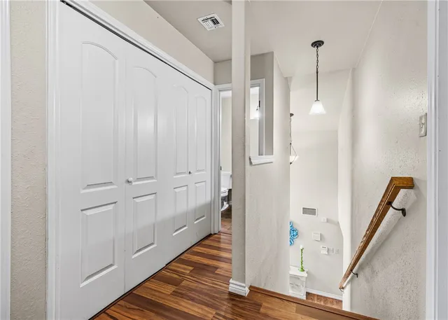 a view of a hallway with wooden floor and staircase
