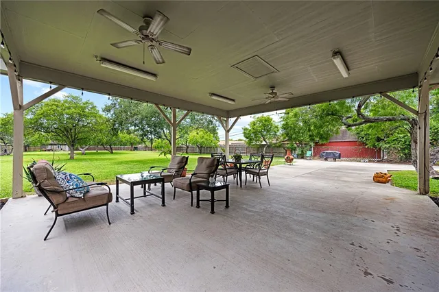 a view of a patio with table and chairs under an umbrella