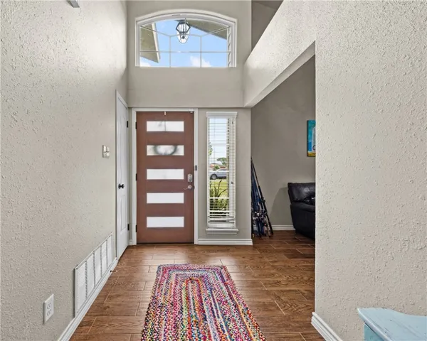 a view of a hallway with wooden floor and a window