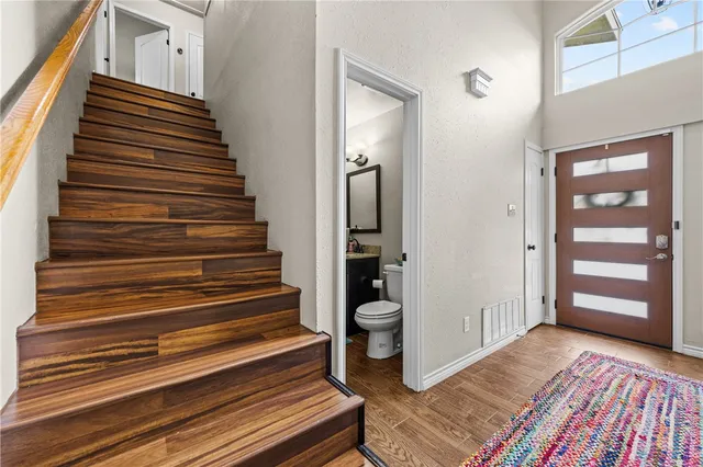 a view of a hallway with wooden floor and stairs