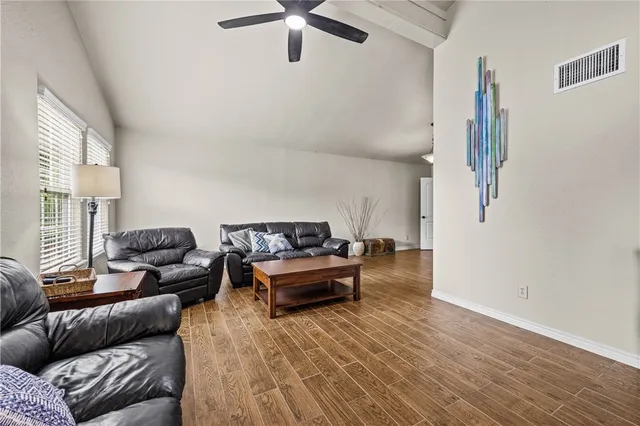 a living room with furniture and a wooden floor