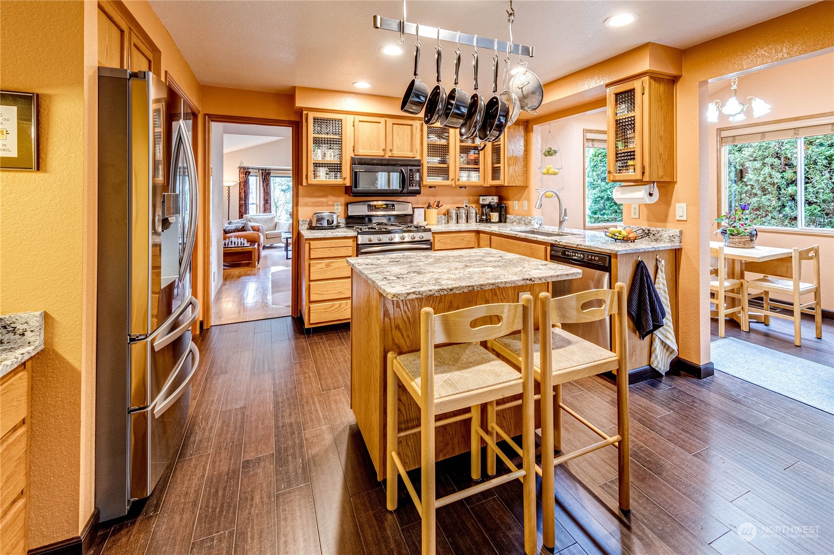 3213 211th Street Southeast Bothell, WA 98021 - Photo 13 of 33 a open kitchen with a table chairs refrigerator and wooden floor