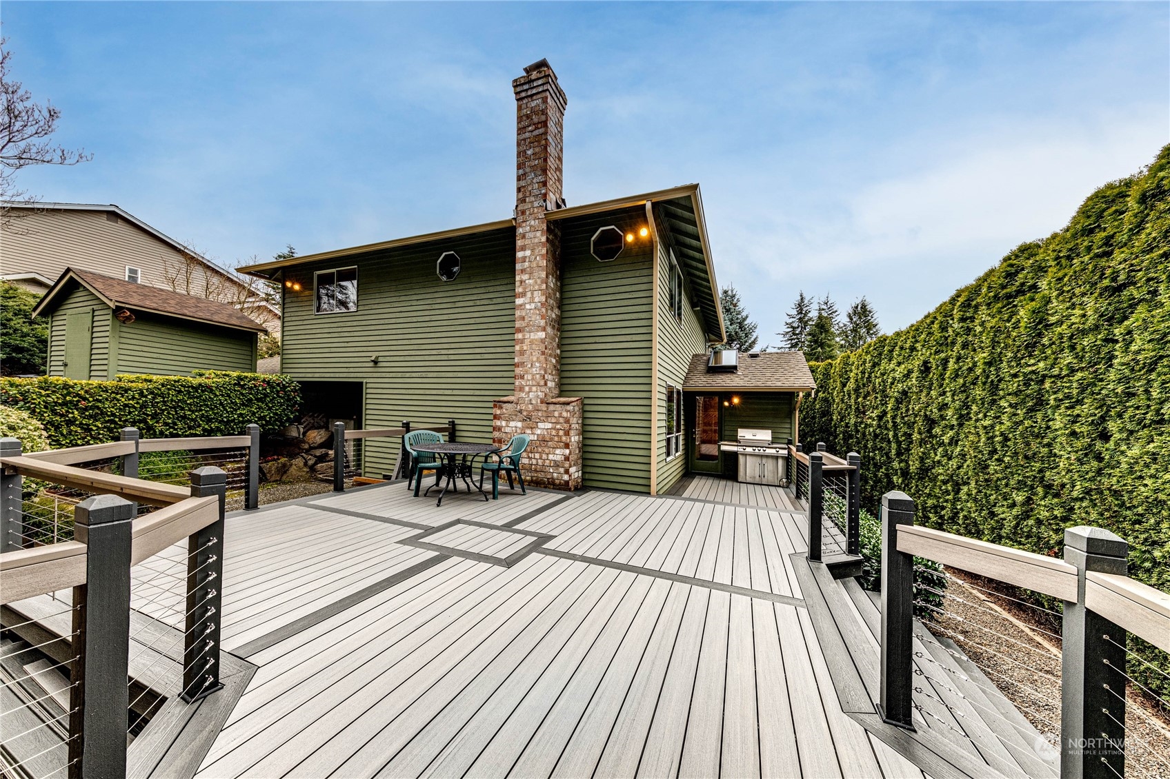 3213 211th Street Southeast Bothell, WA 98021 - Photo 28 of 33 a view of a roof deck with table and chairs a barbeque with wooden floor and fence
