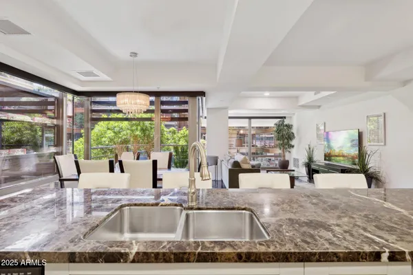 a kitchen with granite countertop a view of living room and patio