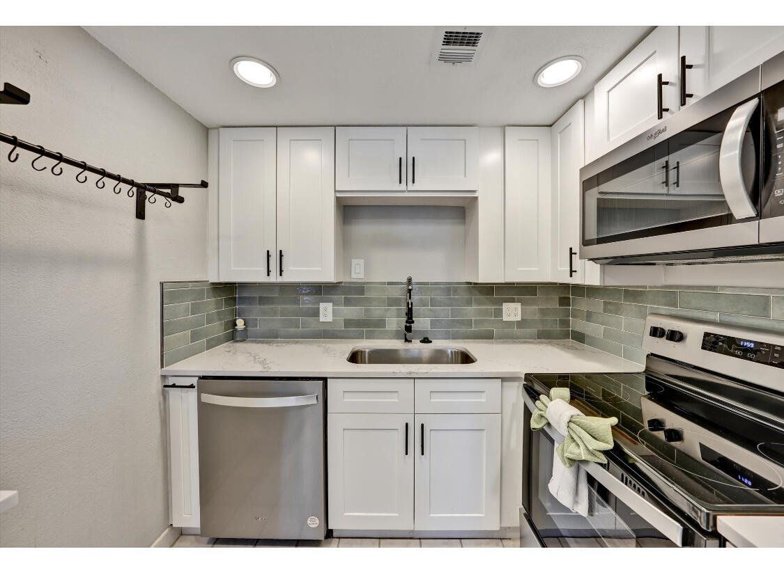 a kitchen with stainless steel appliances a sink stove and cabinets