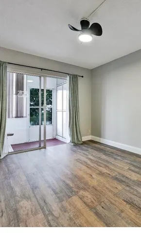 an empty room with floor to ceiling windows and fireplace