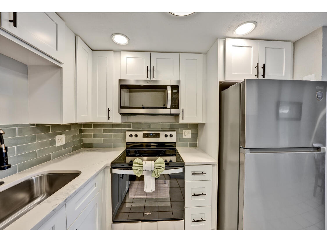 209 Northampton K, Unit K West Palm Beach, FL 33417 - Photo 3 of 24 a kitchen with a refrigerator sink and microwave
