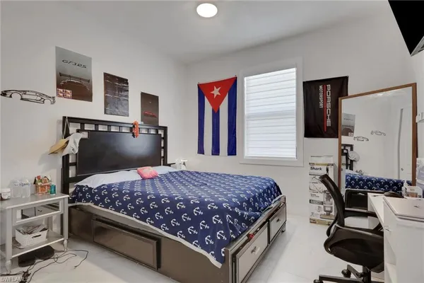 a bedroom with a bed and dresser with mirror