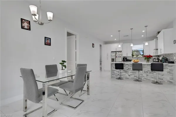 a view of kitchen with stainless steel appliances kitchen island granite countertop dining room cabinets and living room view
