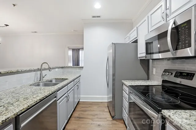 a kitchen with stainless steel appliances granite countertop a sink stove and refrigerator