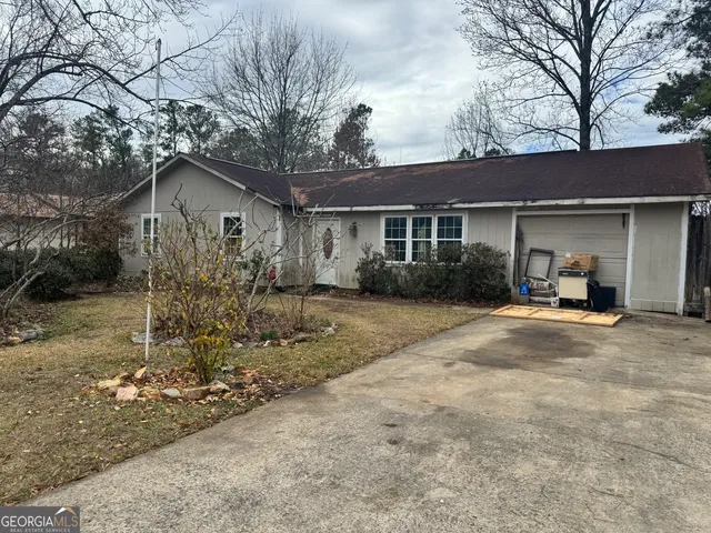 a front view of house with yard and trees around