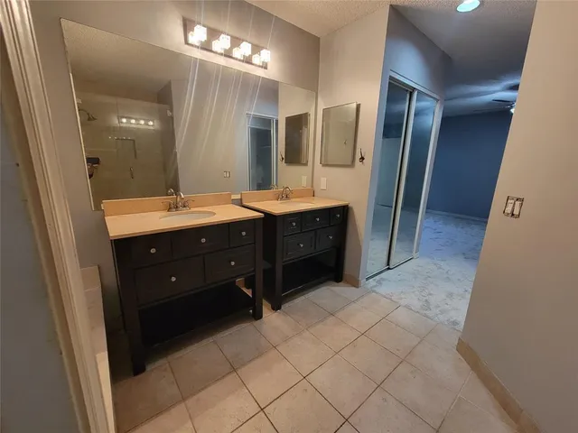 a spacious bathroom with a double vanity sink and mirror