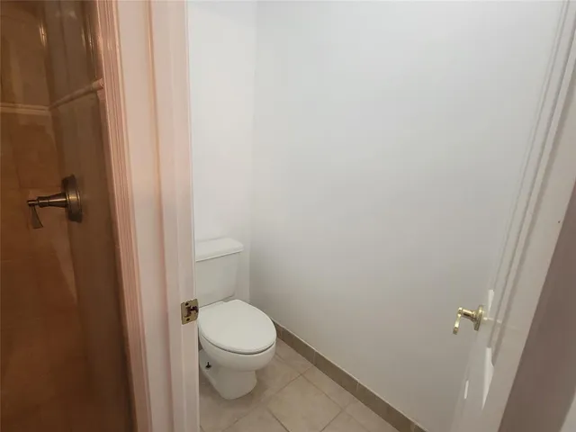 a white toilet sitting next to a shower