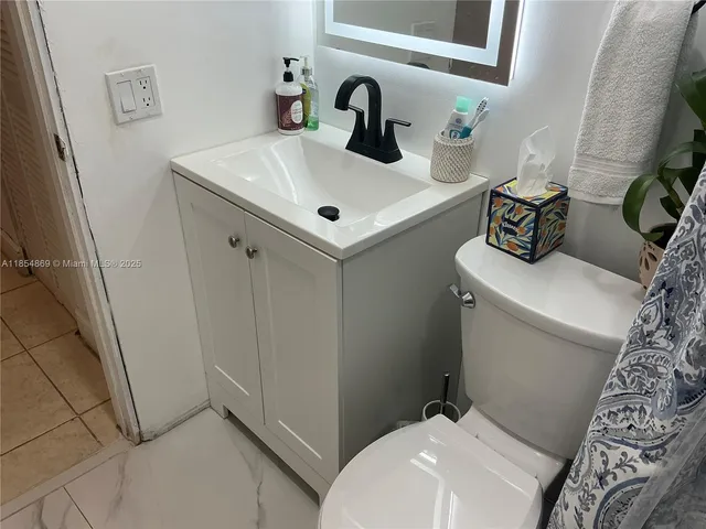 a bathroom with a sink toilet and mirror