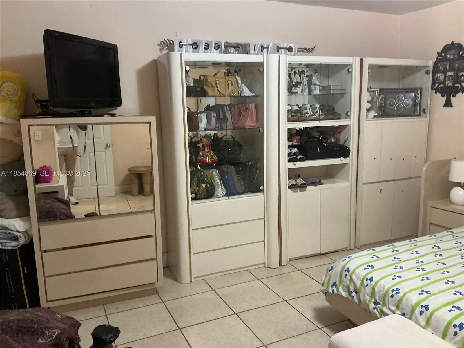 1855 Northwest 32nd Street Miami, FL 33142 - Photo 10 of 23 a bedroom with a bed and flat screen tv