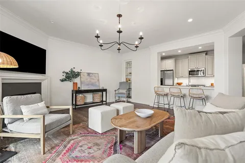 a living room with furniture a flat screen tv and kitchen view