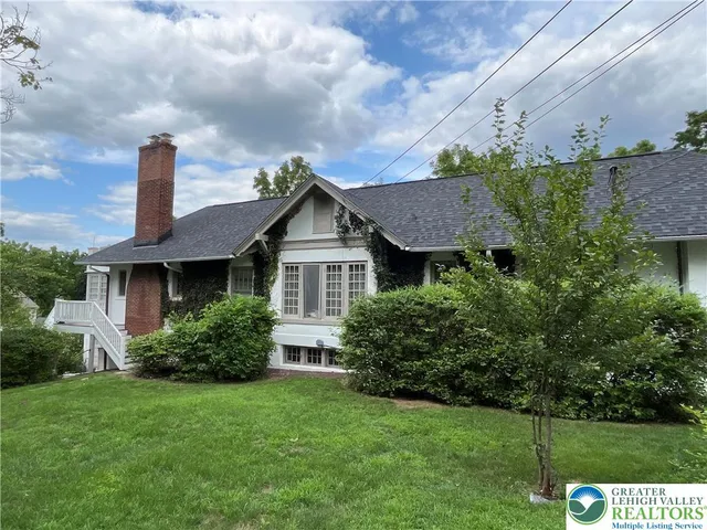a front view of a house with a yard and trees