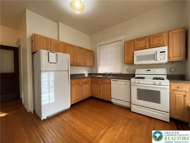 a kitchen with white cabinets and white appliances