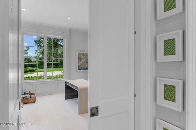 a view of a hallway with wooden floor and a living room