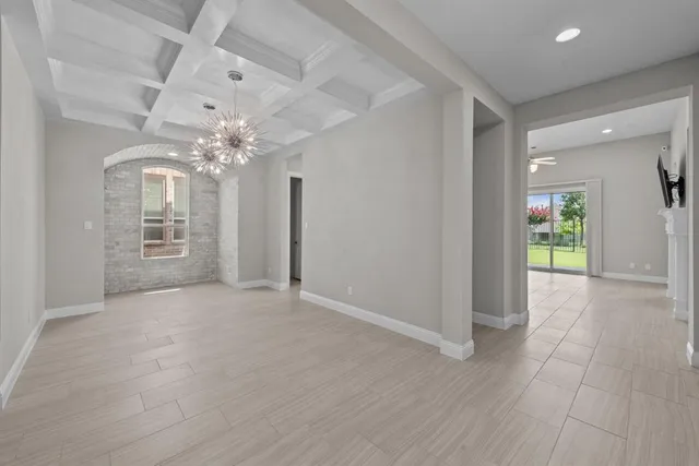 a view of a hallway with wooden floor and chandelier