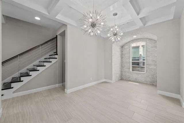 wooden floor in an empty room with a chandelier