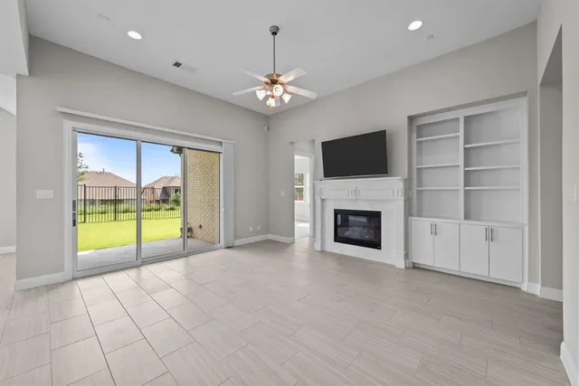a view of an empty room with a fireplace and a window