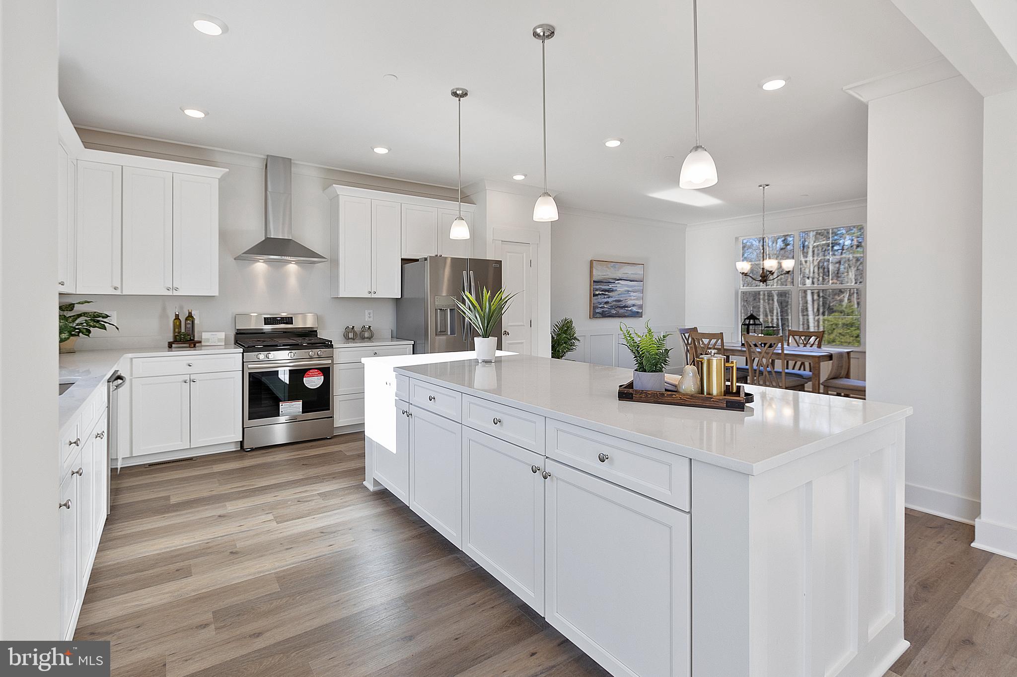 1333 German Driveway Hanover, MD 21076 - Photo 13 of 56 a large white kitchen with kitchen island a sink a stove a center island a dining table and chairs