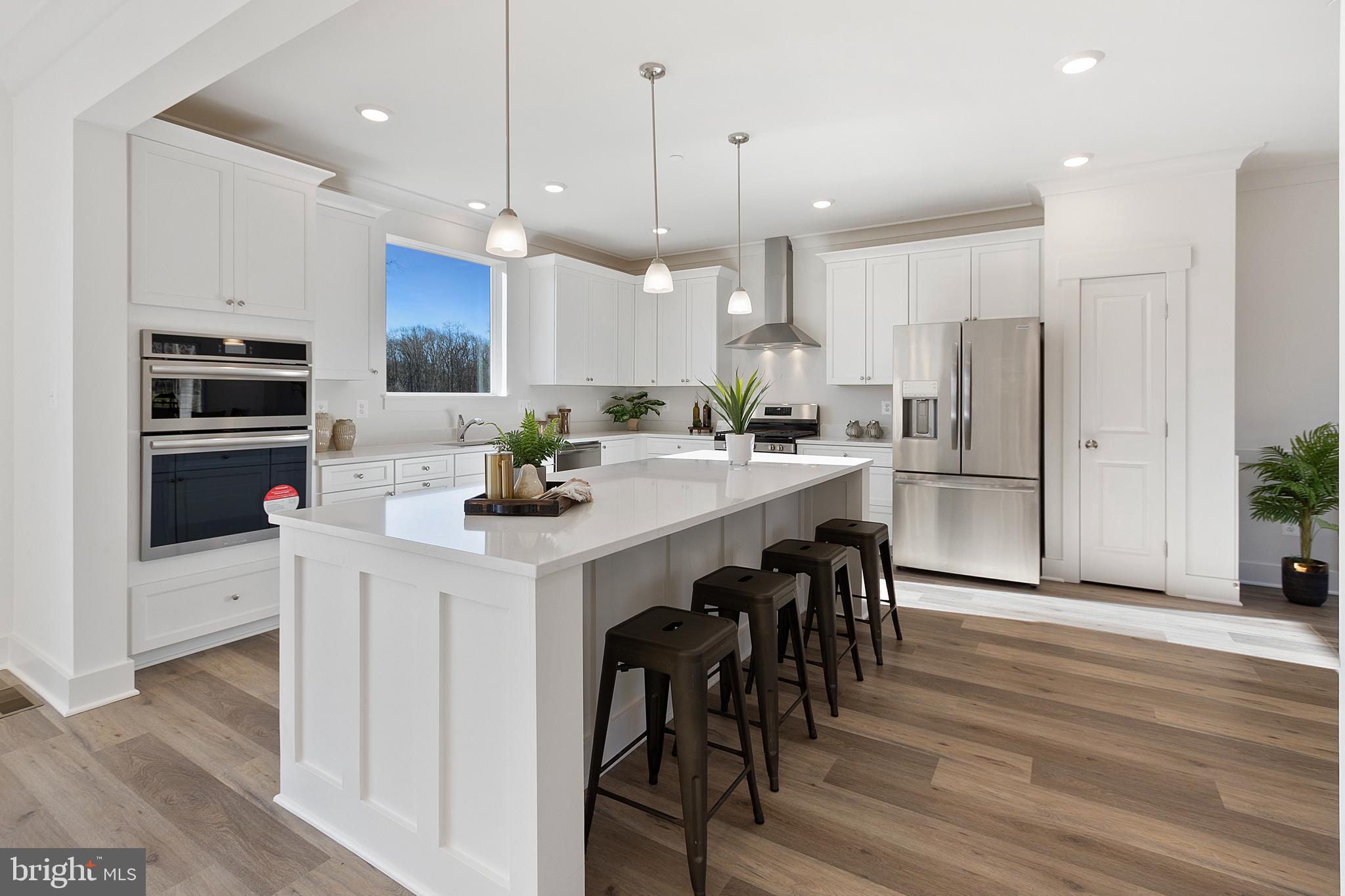 1333 German Driveway Hanover, MD 21076 - Photo 14 of 56 a kitchen with a dining table chairs refrigerator and microwave