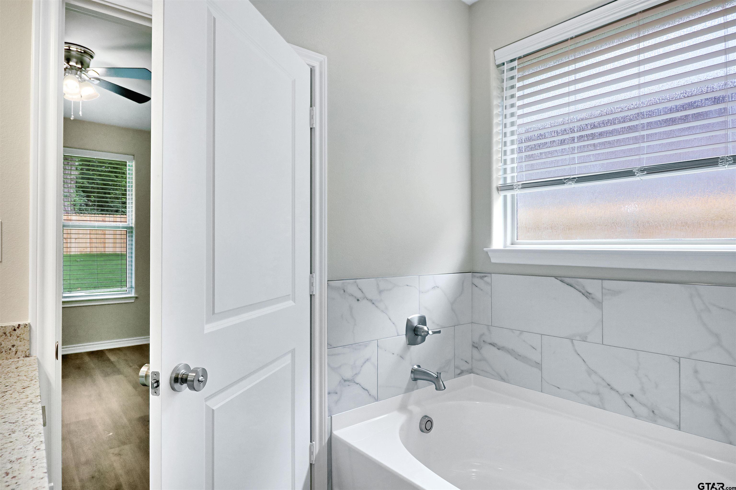 3053 Guinn Farms Road Tyler, TX 75707 - Photo 21 of 32 a bath tub sitting next to a window