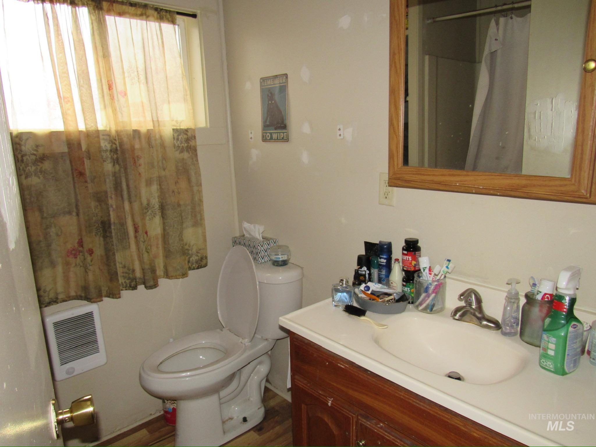 317 Esther Street Kooskia, ID 83539 - Photo 14 of 15 Full bath with vanity, heating unit, a shower with curtain, and dark wood-type flooring