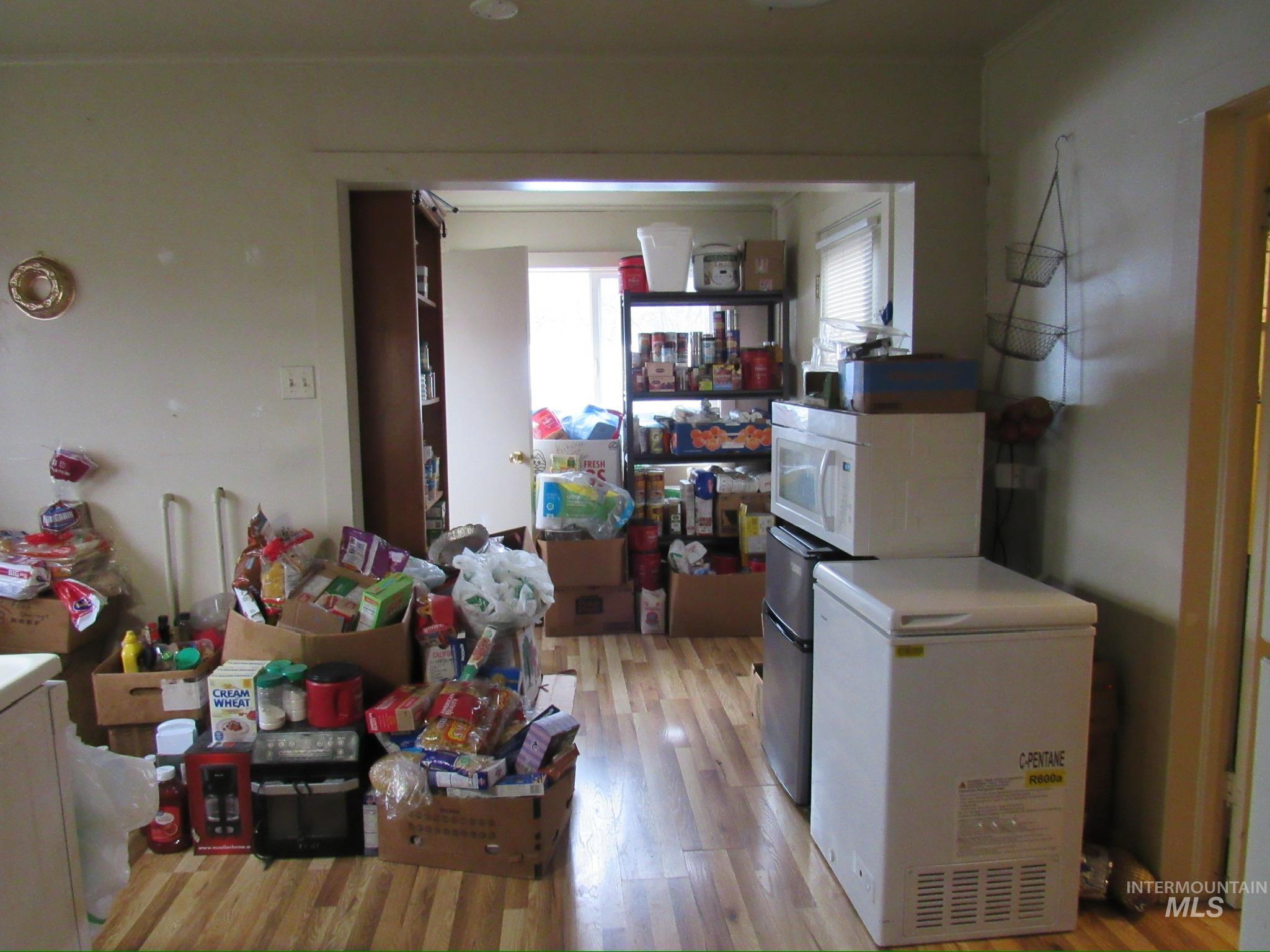317 Esther Street Kooskia, ID 83539 - Photo 6 of 15 Kitchen with white microwave, light wood-style flooring, and washer / clothes dryer