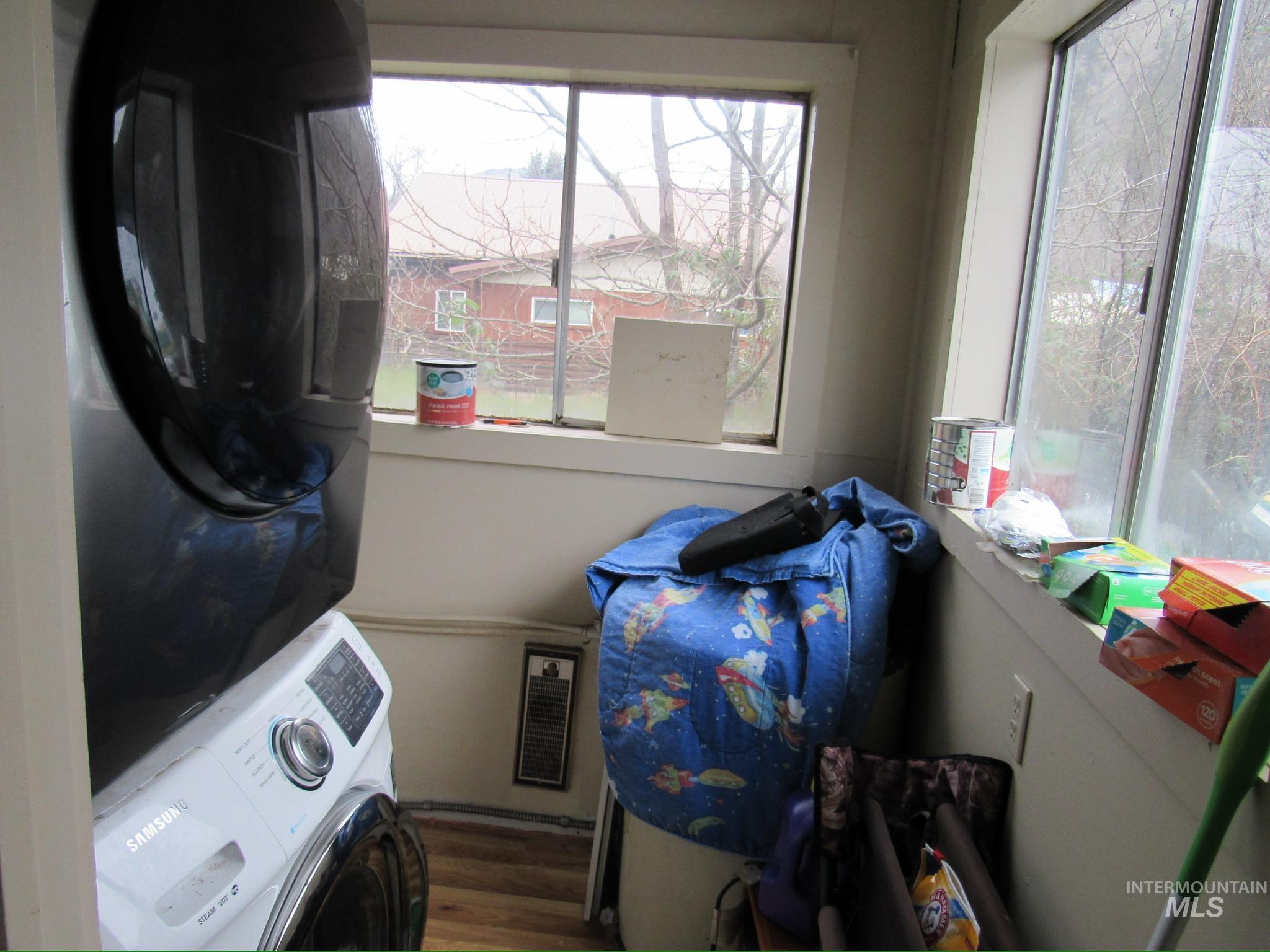 317 Esther Street Kooskia, ID 83539 - Photo 9 of 15 Laundry room with stacked washing machine and dryer and dark wood-style flooring